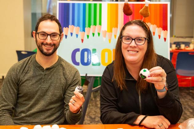Two adults pose with their custom hacky sacks