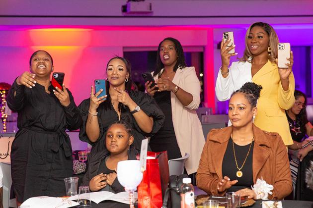 A group of women are recording on their phones 