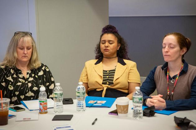 Three women take part in a meditation exercise 