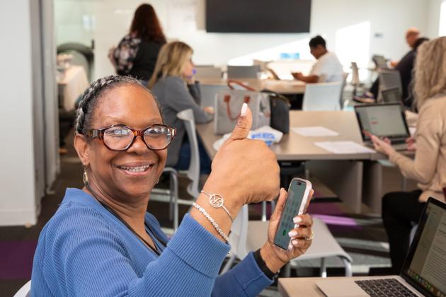 A woman gives a "thumbs up" while working at a UFT phone bank in Queens. 