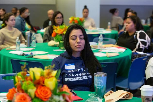 A school counselor in attendance takes part in a guided meditation.