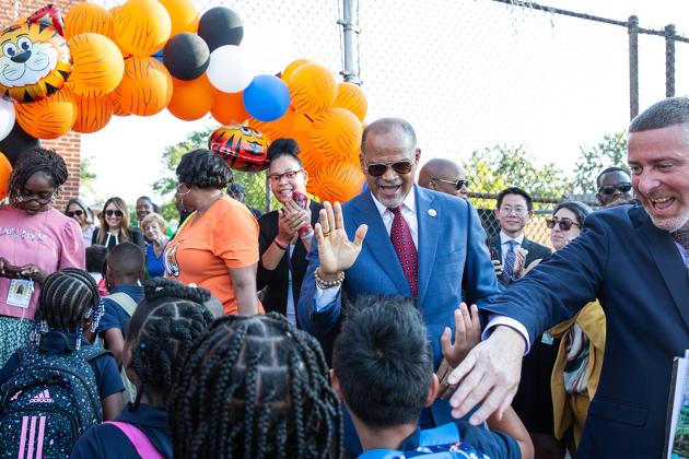A man gives a high five to a student 