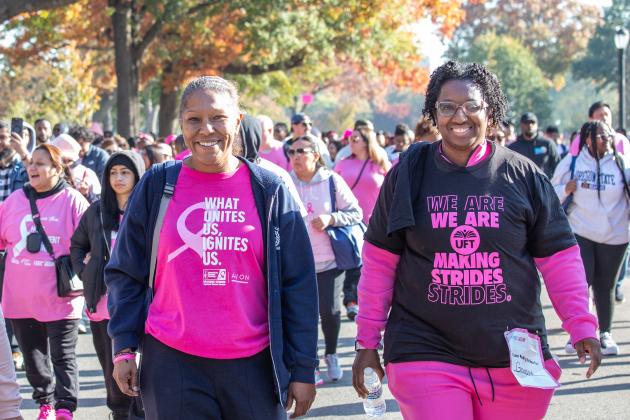 Two UFT members at the Queens Making Strides Walk on Oct. 20, 2024 smile for a photo while walking. 