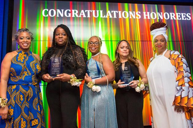A group of award winners pose on the stage 