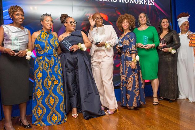 A group of award winners pose on the stage 