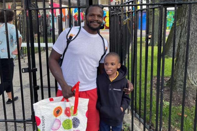 A father and son stand outside a school