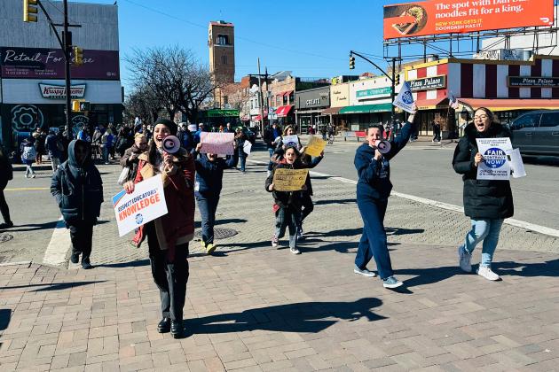 Members march down a street in protest