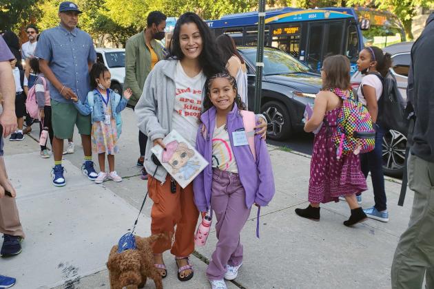 A mother and daughter stand outside a school