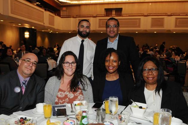 A group of members pose for a picture at a table
