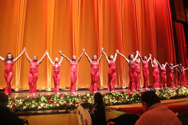 Students perform with the Rockettes on stage