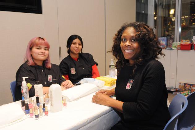 A librarian takes a photo with cosmetology students at the UFT/Coalition for the Homeless holiday toy drive and celebration on Dec. 7, 2024