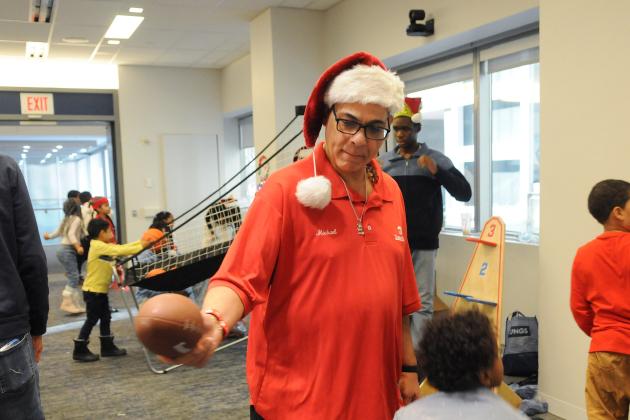 A volunteer assists with the football target station at the UFT/Coalition for the Homeless holiday toy drive on Dec. 7, 2024. 
