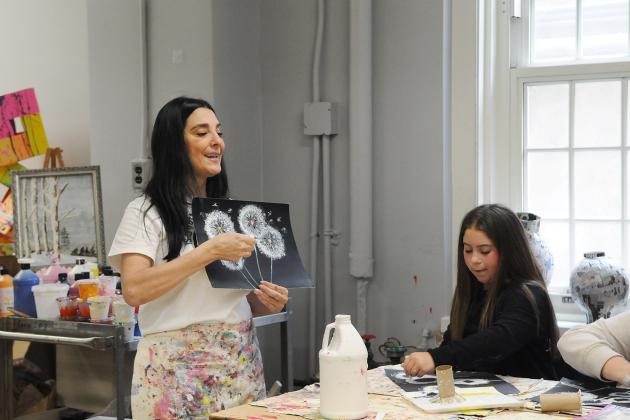 A teacher gives instruction on an art project in preparation for an art show at IS 34 on Staten Island.