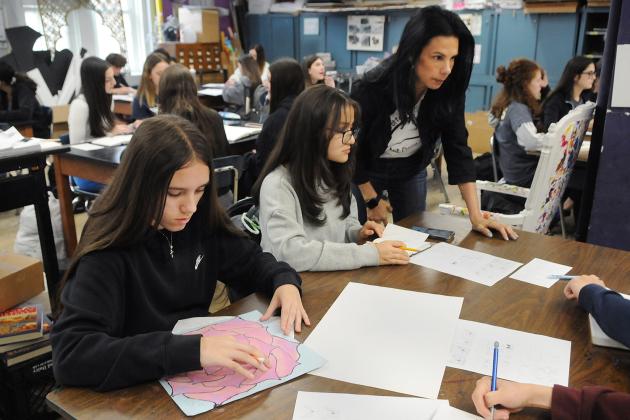 An art teacher works with her students in preparation for an art show at IS 34 on Staten Island.