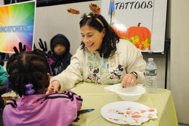 A teacher assists a student at the 2024 UFT Middle School Division’s annual Thanksgiving Luncheon on Nov. 23, 2024 at UFT headquarters. 