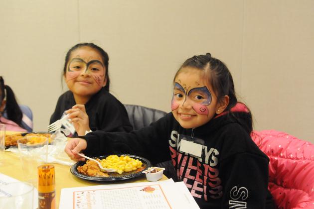 Two students smile for a photo while eating lunch at the UFT Middle School Division’s annual Thanksgiving Luncheon held at UFT headquarters on Nov. 23, 2024. 