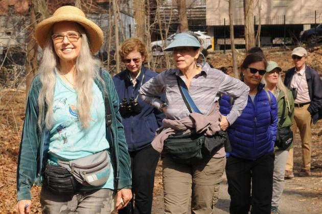 A woman leading a group through the park 