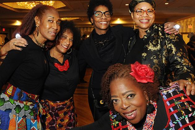 A group of women pose for a photo at a table. 