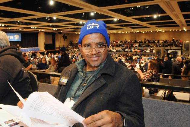 A man in a blue beanie looks over the legislative priorities being brought up at Lobby Day 
