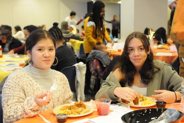 Two students pose for a photo while eating their lunch