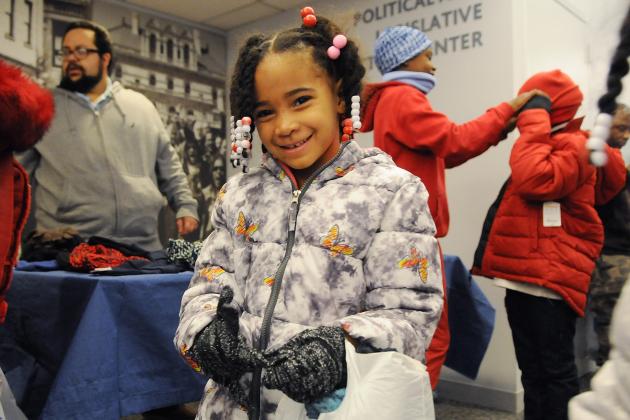 A girl poses for a photo showing off her new coat and gloves