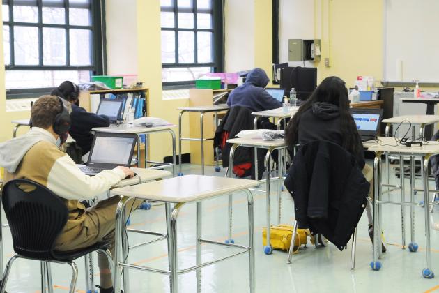Four students doing schoolwork while being socially distant.