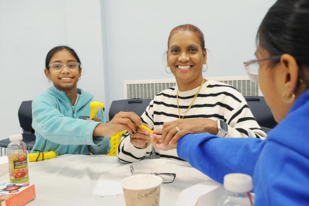 A woman and child smile for a photo while taking part in an activity at the Staten Island Family Summit on Nov. 9 at the UFT Staten Island borough office. 