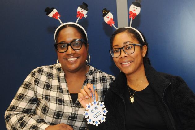Two teachers smile for a photo while showing off one of their crafts at the UFT/Coalition for the Homeless holiday toy drive and celebration on Dec. 7, 2024. 