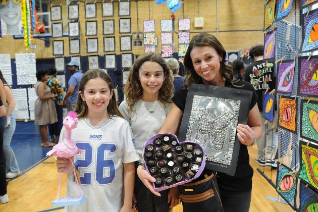 A mother and her daughters pose for a picture during an art show at IS 34 on Staten island. 