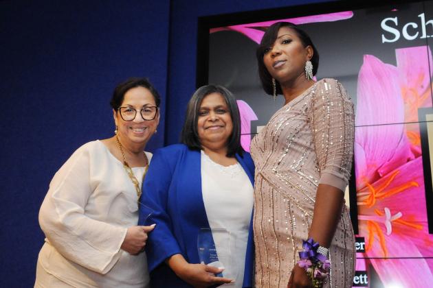 Two award winners pose for a photo with their chapter leader on the right.