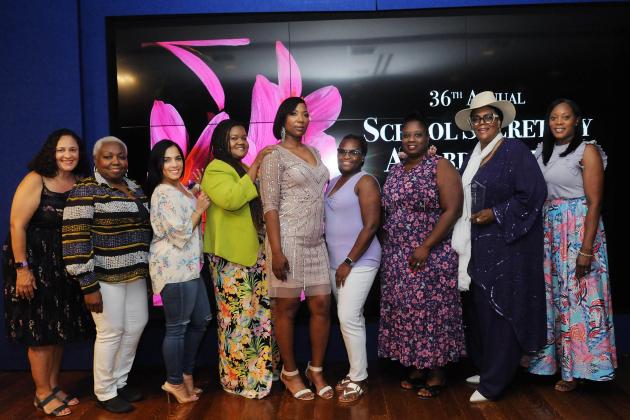 A group of award winners take a photo on the stage. 
