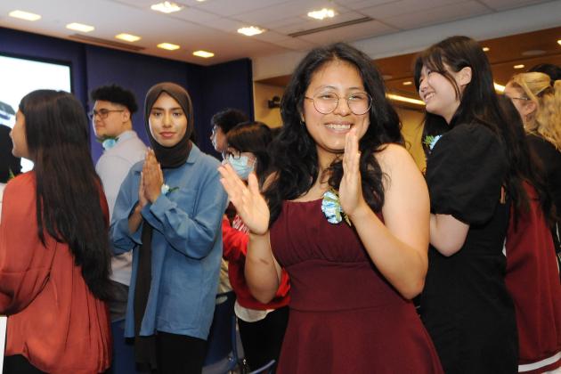 A woman claps as she arrives to an event