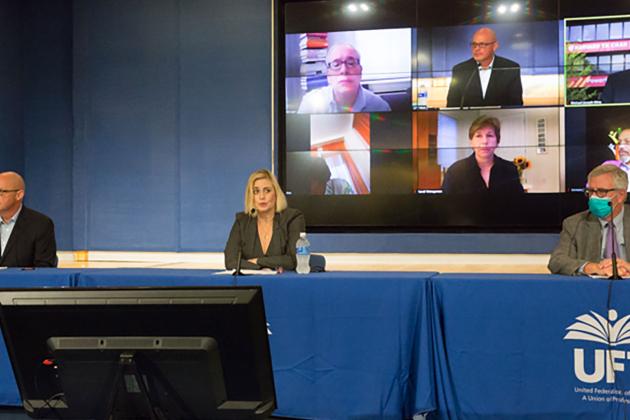 Three UFT officials speaking at a press conference podium
