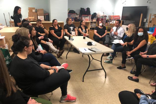 A group of staff members gather together in a circle for a discussion 