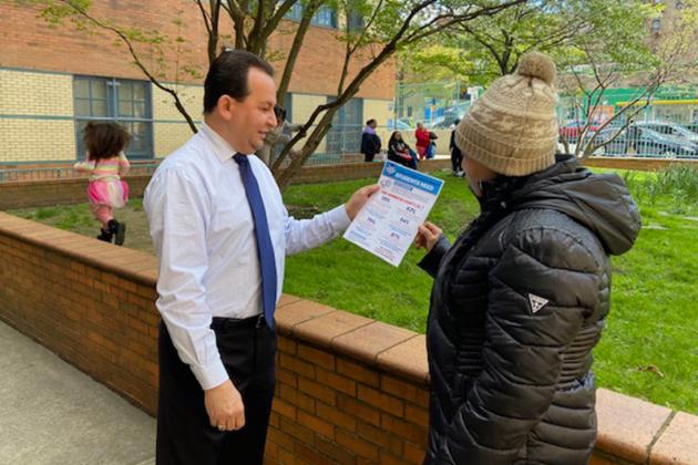 A teacher hands a flier to a parent