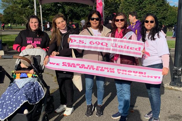 A group of UFT members pose with a banner showing their school's name
