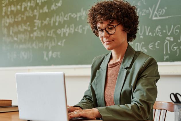 Teacher typing on laptop
