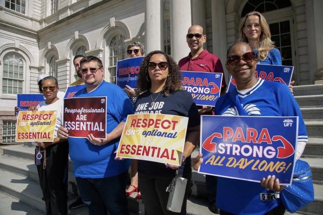 UFt members holding signs standing in front of NY City Hall