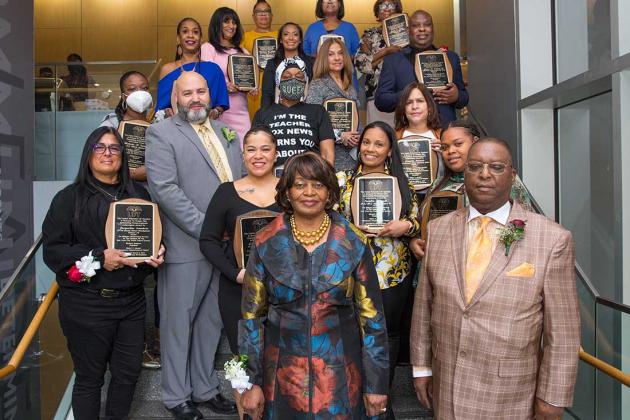 A large group of award winners pose on the stairs for a photo