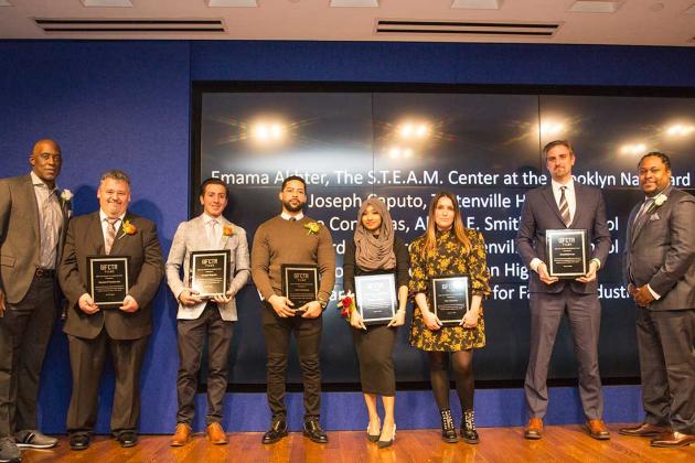 A group of award winners pose on the stage 