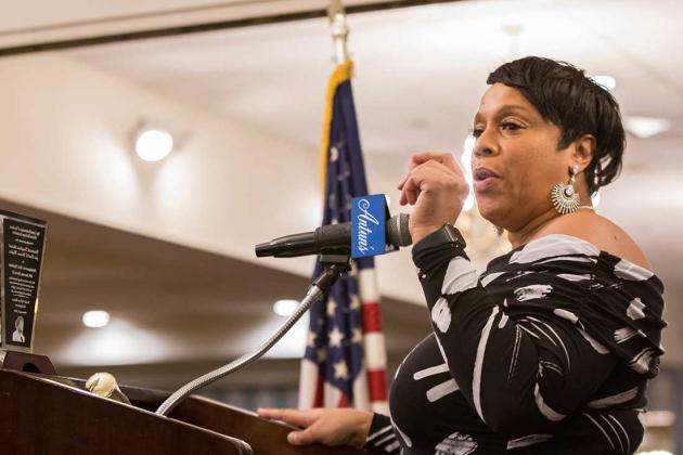 A woman is at the podium accepting an award. 