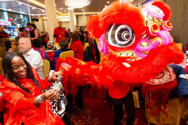 Retiree Zina Burton-Myrick, the former UFT District 5 representative, feeds money to the lion for good luck.