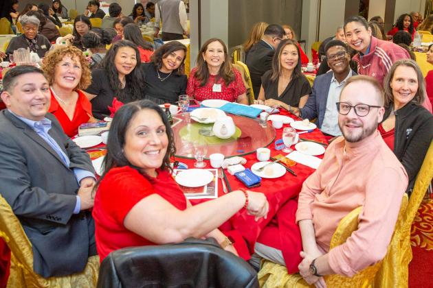 Chapter Leader Sandy Wong (standing, right) of PS 30 in the Bronx stops by to visit with UFT members from Queens, including Borough Representative Tabio DeCruz (far left).