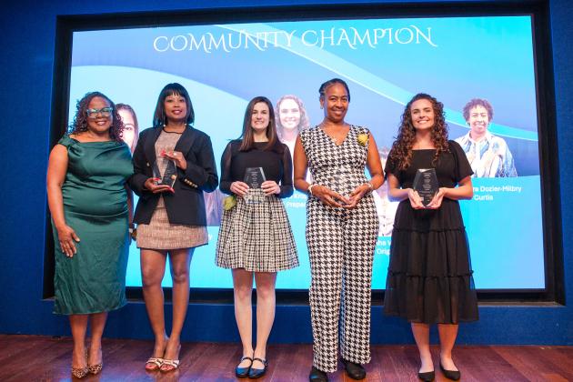  The Community Champion honorees proudly hoist their plaques alongside UFT Vice President for Academic High Schools Janella Hinds at the 2026 UFT Academic High School Awards ceremony. 