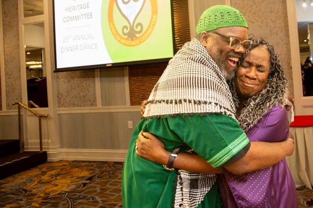 Award-winning teacher Mavis Yon (right) accepts a warm, congratulatory hug from UFT District 9 Representative Aqeel Williams.