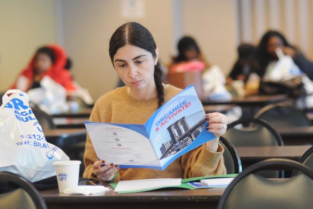 Jessica Juntz, a parent of a student at PS 889 in Flatbush, Brooklyn, browses her conference program.
