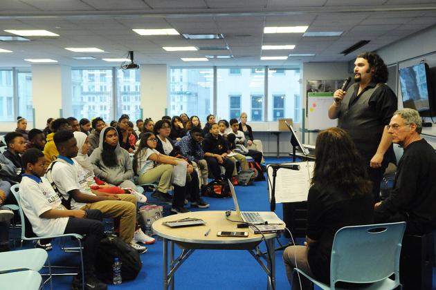 Group of students watching man with microphone