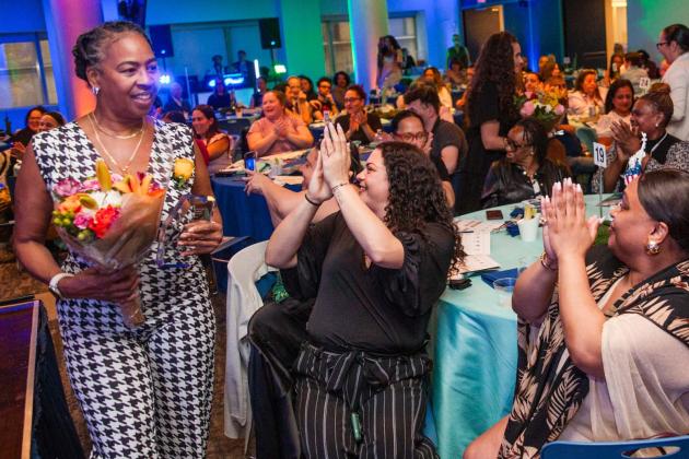 Receiving her flowers amid applause is school secretary and Community Champion Award-winner Cassandra Dozier of Curtis HS on Staten Island.