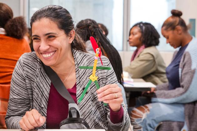 Teacher Alyssa Rosado of PS 185 in Manhattan shows off the popsicle stick figure she made as part of exploring ways to build students’ foundational reading skills through joyful learning.
