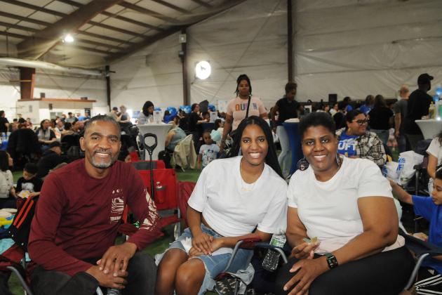 A teacher and her family take a group photo while seated during the 2025 UFT Family Day. 